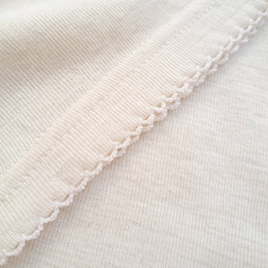 Detailed close-up of fine ribbed merino wool fabric showing softness and natural elasticity
