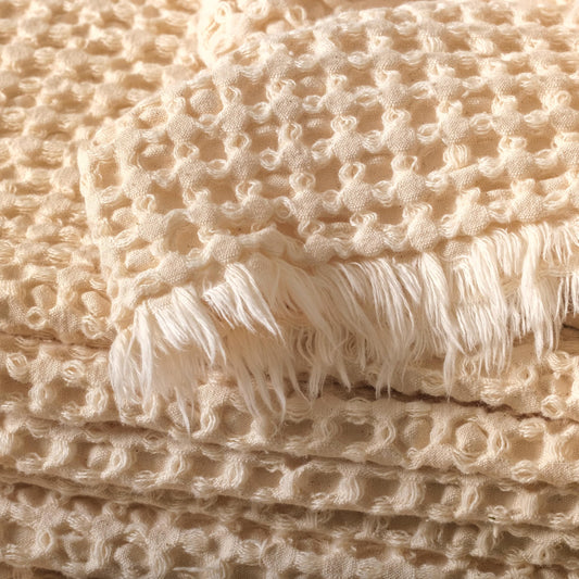 Close-up of the cotton waffle fabric texture and edge detail in natural undyed color