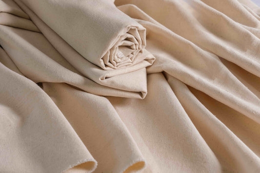 Raw undyed cotton canvas fabric stacked in layers, ideal for dye testing, bags, aprons, and home textiles