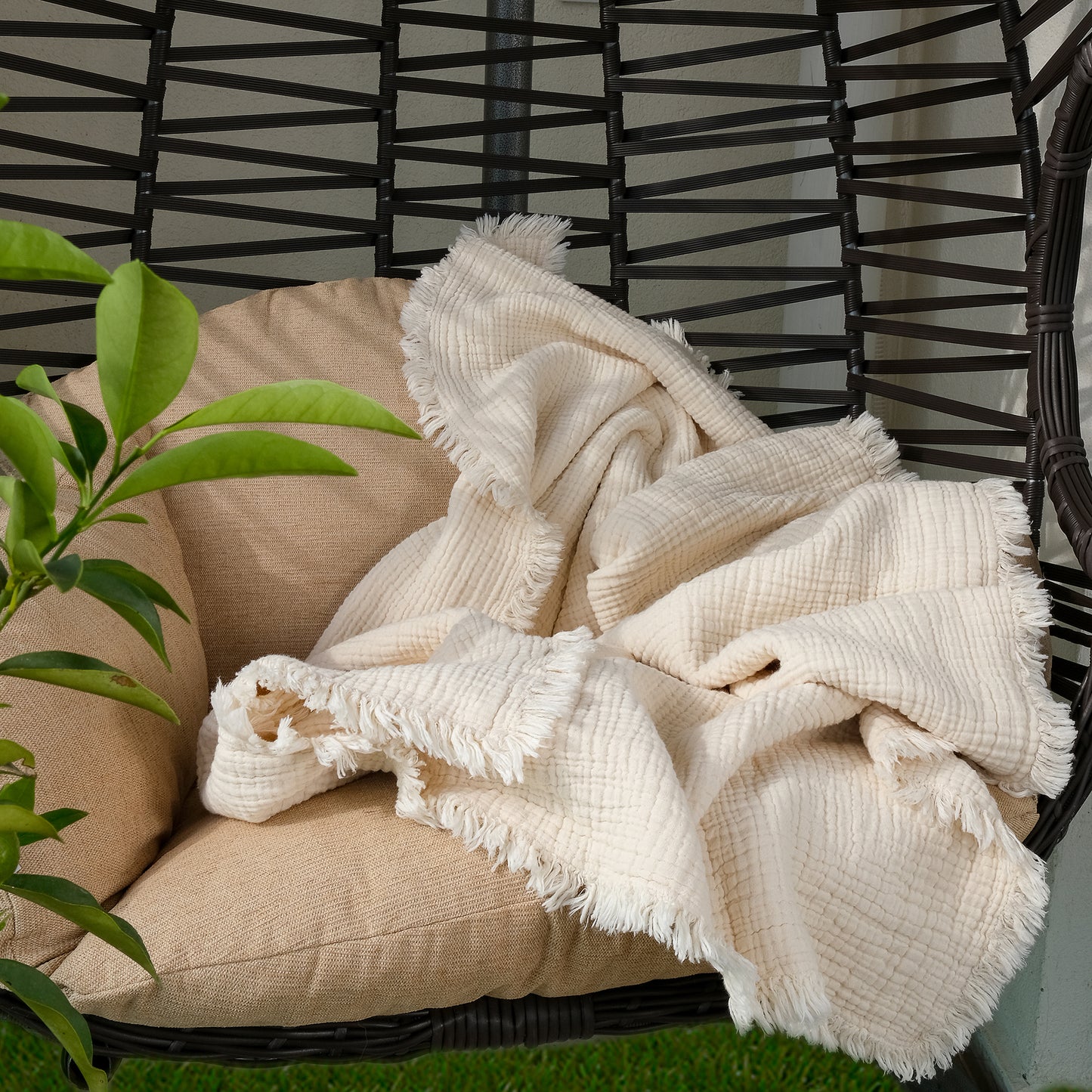 The 8-layer crinkle gauze baby swaddle blanket draped over a chair, emphasizing its soft texture and stylish appearance.