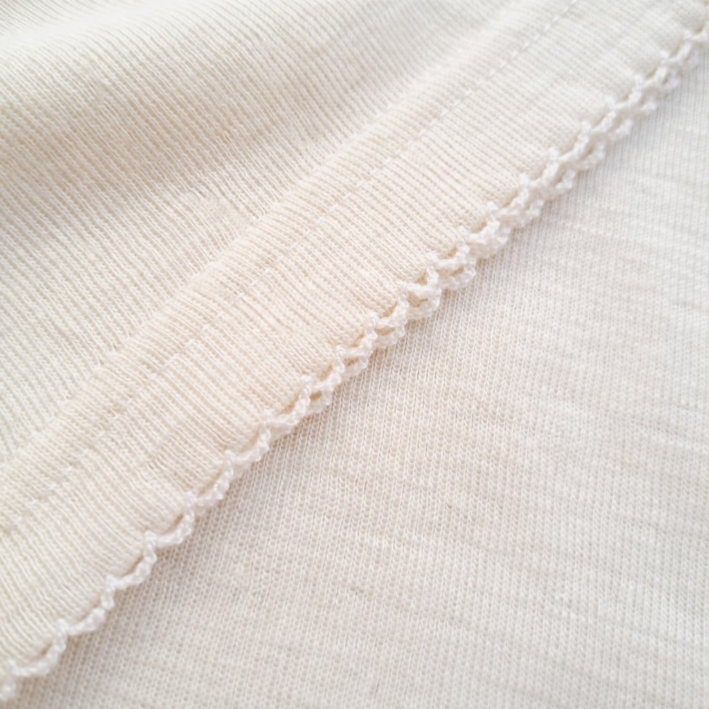 Detailed close-up of fine ribbed merino wool fabric showing softness and natural elasticity