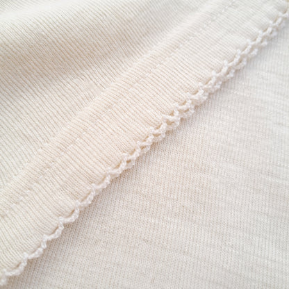 Detailed close-up of fine ribbed merino wool fabric showing softness and natural elasticity