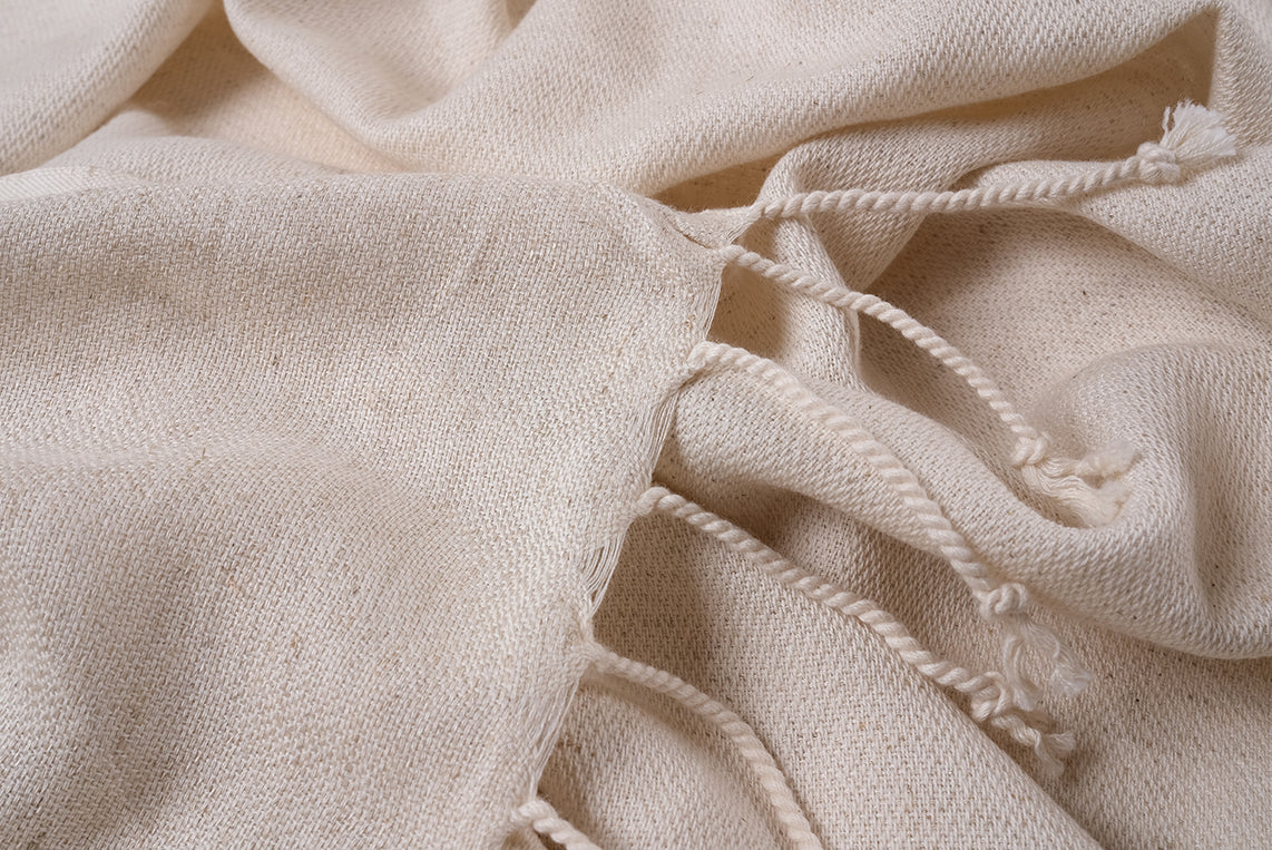 Close-up detail of handwoven undyed peshtemal fringes, natural cotton linen