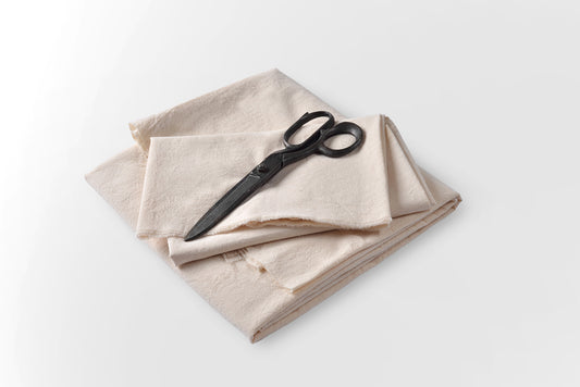 Flat lay view of undyed cotton fabric showing natural surface and weave structure
