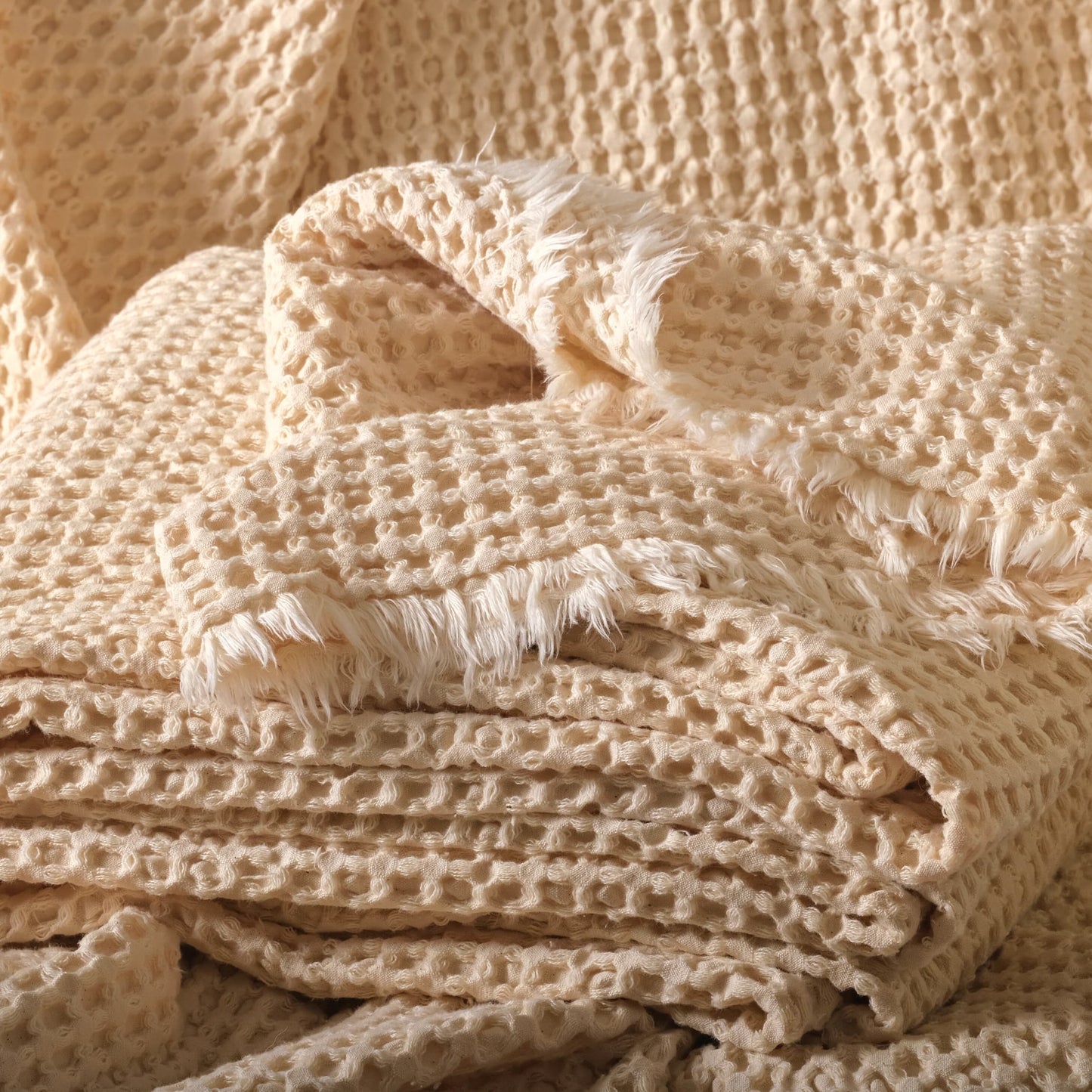 Undyed 100% cotton waffle fabric in natural color, stacked to show the soft honeycomb texture.