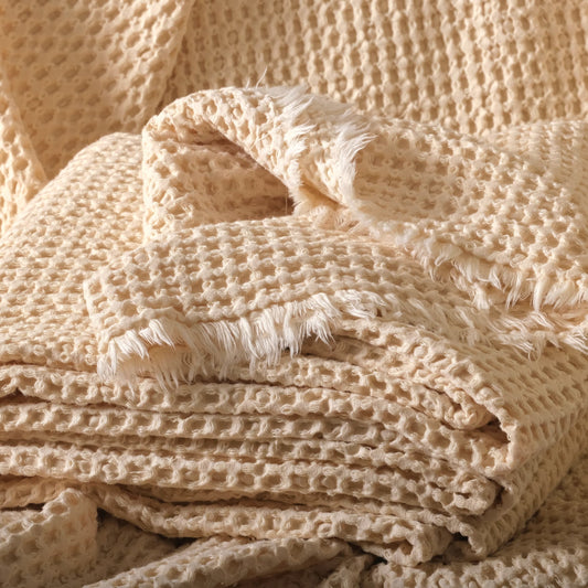 Undyed 100% cotton waffle fabric in natural color, stacked to show the soft honeycomb texture.