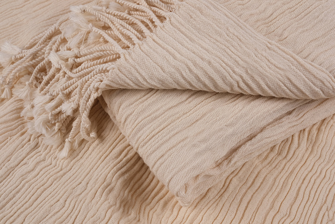Close-up view of folded undyed cotton linen peshtemal showing natural fabric texture
